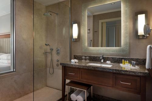een badkamer met een douche, een wastafel en een spiegel bij Istanbul Marriott Hotel Asia in Istanbul