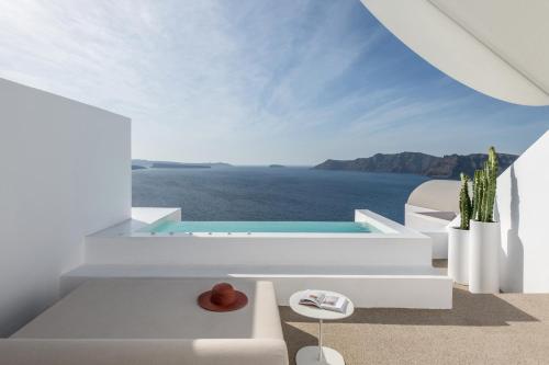 a white house with a view of the ocean at The Saint Hotel in Oia
