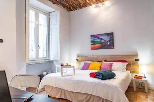 um quarto com uma cama grande e almofadas coloridas em Apple House al Duomo by Wonderful Italy em Turim