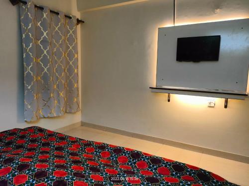 Un dormitorio con una cama y un televisor de pantalla plana. en Al Sakhawat Hotel, en Rawalpindi