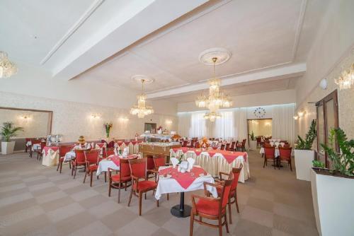 a banquet hall with tables and chairs and chandeliers at Savoy Spa & Kurhotel in Františkovy Lázně