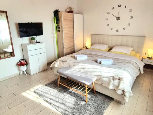 a bedroom with a large bed with a clock on the wall at Studio Apartment Lino in Skrbčići