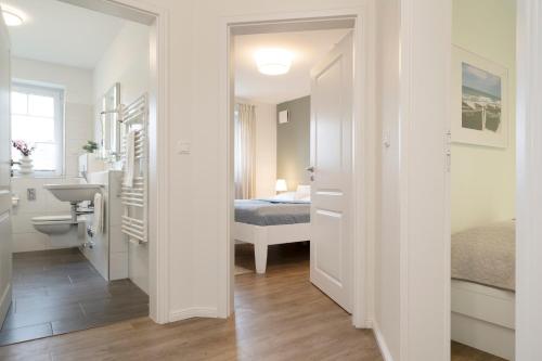 łazienka z umywalką i łóżkiem w pokoju w obiekcie Schützenweg 3 Elwert w mieście Kellenhusen