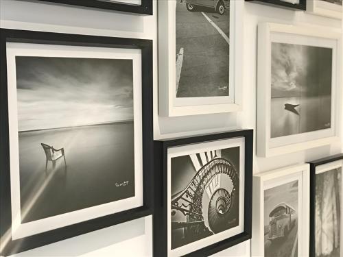 un grupo de fotografías enmarcadas en una pared en Sweet Holiday, en Porto Vecchio