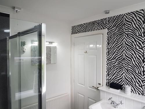 a bathroom with a shower and a sink and a mirror at No6 High Street in Edwinstowe