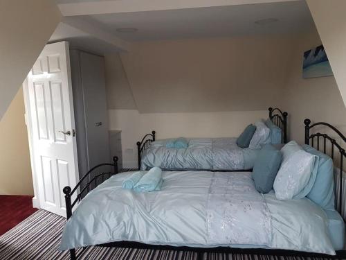 a bedroom with two beds with blue pillows on them at No6 High Street in Edwinstowe