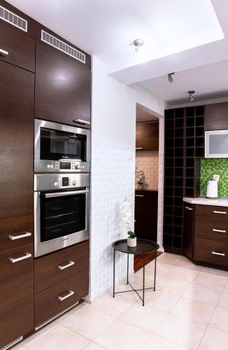 a kitchen with stainless steel appliances and a table at ClickTheFlat Piękna Center Apart Rooms in Warsaw