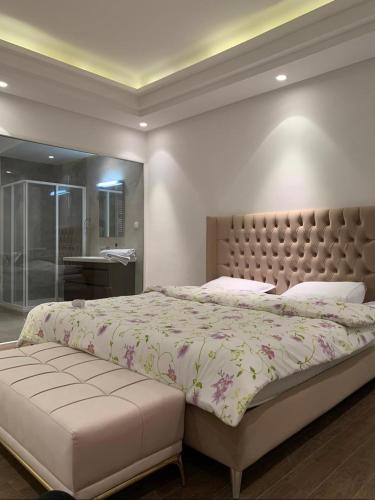 - une chambre avec un grand lit et une tête de lit touffetée dans l'établissement S+3 luxurious apartment Hermes design in les jardins de Carthage Lac2, à Sidi Daoud