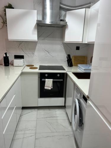 a white kitchen with a stove and a dishwasher at Apartament La Mata in La Mata