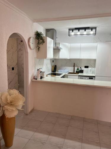 a kitchen with white cabinets and a flower in a vase at Apartament La Mata in La Mata