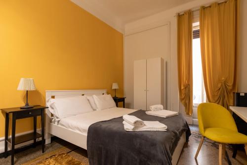 1 dormitorio con cama y pared amarilla en Granello Suite Central, en Génova