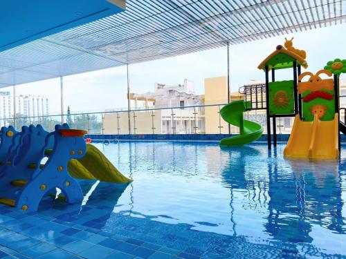 una piscina con 2 toboganes en el agua en Nice Apartment Goldsea Vũng Tàu 1805 en Vung Tau