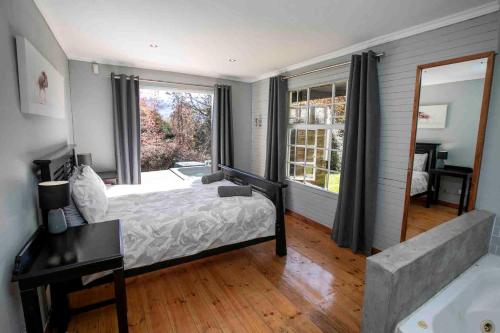 1 dormitorio con cama y ventana grande en Bergwinds, en Underberg