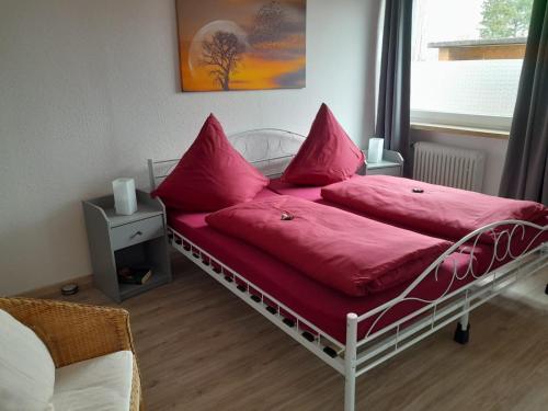 a bedroom with a bed with pink pillows on it at Ferienwohnung Im Birkenweg in Mörsdorf