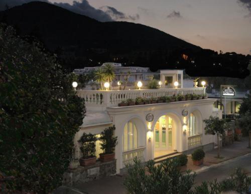 Una gran casa blanca con luces encima. en Hotel Rosetta en Ischia