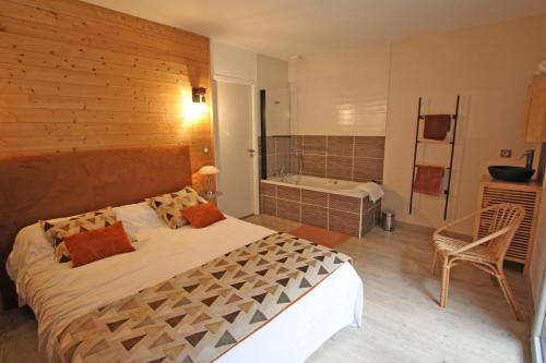 een slaapkamer met een groot bed en een bad bij La maison de l'auzette in Limoges