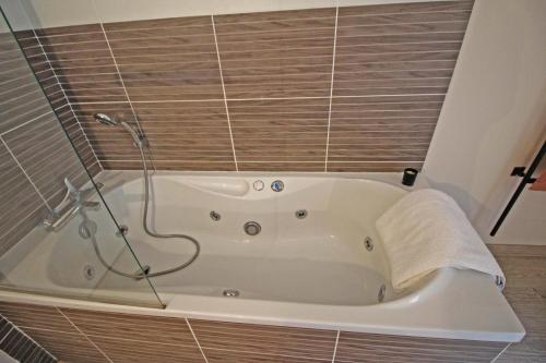 een badkamer met een bad en een douche bij La maison de l'auzette in Limoges