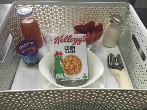 a lunch box with a bowl of cereal and milk at The Granary Lodge Bed & Breakfast in Thurso