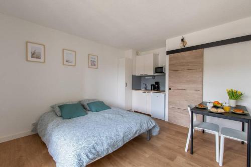 1 dormitorio con cama, escritorio y cocina en Escapade Ensoleillée * wifi * mer à 10 minutes, en Carnon-Plage