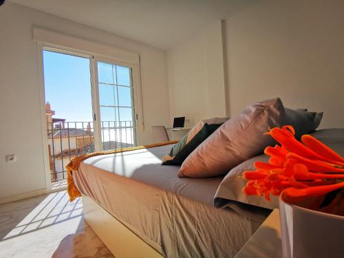 Un dormitorio con una cama grande con una ventana grande. en Luz de la Marina, en Almuñécar