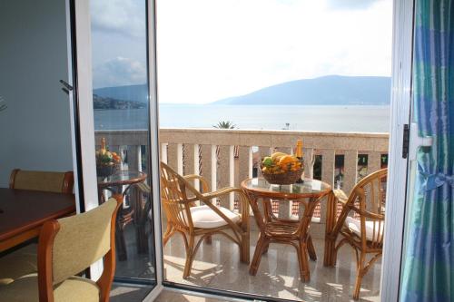 einen Balkon mit einem Tisch und Stühlen sowie Meerblick in der Unterkunft Tazex Apartments in Herceg-Novi