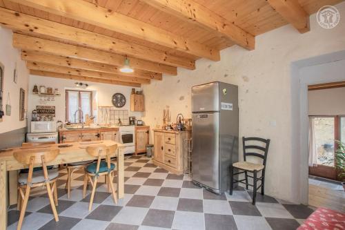 cocina con nevera, mesa y sillas en Gite la Montagnette en Ruffieux