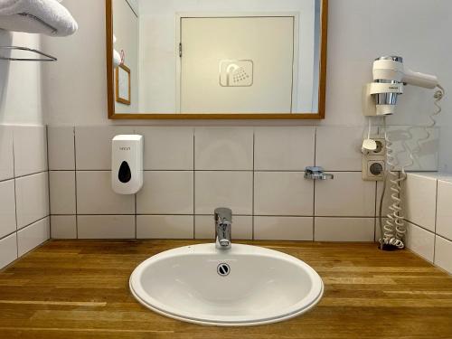 a bathroom with a sink and a mirror at Long John's Pub & Hotel in Amersfoort
