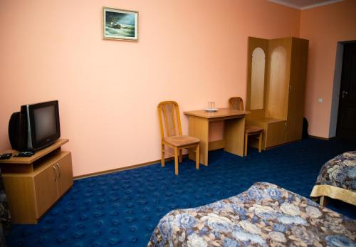 um quarto com duas camas e uma televisão e uma mesa em Avalon em Kremenchuk