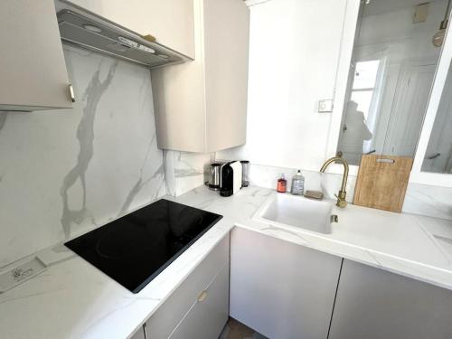 een witte keuken met een wastafel en een magnetron bij Charmant appartement au centre de Tours in Tours