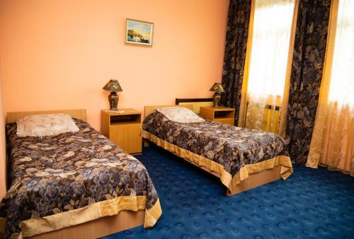 Habitación de hotel con 2 camas y alfombra azul en Avalon en Kremenchuk