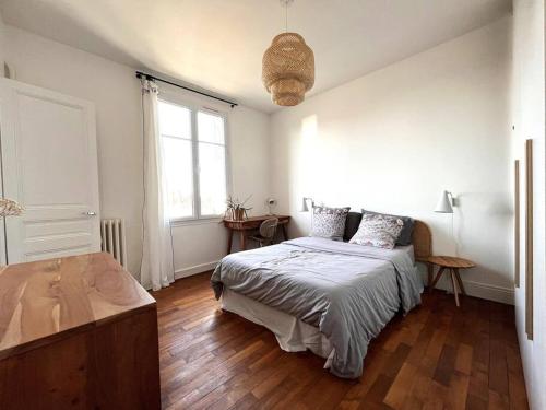 una camera bianca con letto e pavimento in legno di Charmant appartement au centre de Tours a Tours