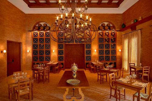 a dining room with a chandelier and tables and chairs at The Westin Resort, Costa Navarino in Romanós
