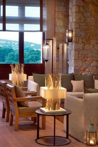 a living room with a couch and chairs and a table at The Westin Resort, Costa Navarino in Romanós
