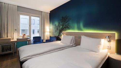 two beds in a hotel room with the aurora borealis at Thon Hotel Nordlys in Bodø