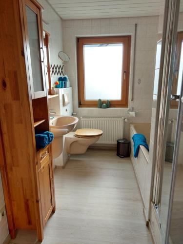 トラーベン・トラーバッハにあるFerienwohnung Tintemannのバスルーム(洗面台2台、トイレ付)、窓が備わります。