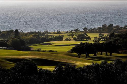 a golf course with the ocean in the background at The Westin Resort, Costa Navarino in Romanós
