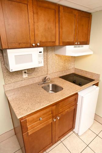 a kitchen with a sink and a microwave at The Schooner Inn in Virginia Beach