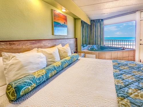 a bedroom with a bed with a view of the ocean at The Schooner Inn in Virginia Beach