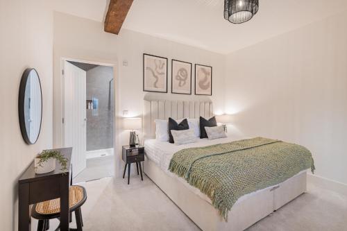 a white bedroom with a large bed and a table at Willow, a luxury rural retreat in Staveley