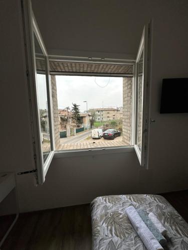 a bedroom with a window with a view of a street at LOCANDA LA CAMPAGNOLA orari check in dalle 1130 alle 1530 e dalle 1830 alle 2330 in Vignola