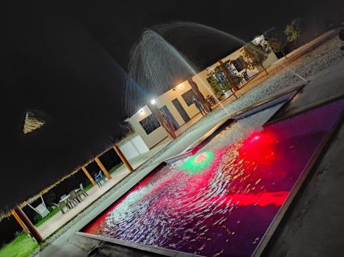 a water fountain in the middle of a pool at night at Parcela el paraiso in Doradal