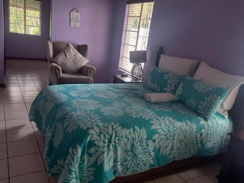 una camera con letto e piumone blu di The Sanctuary Guesthouse a Empangeni