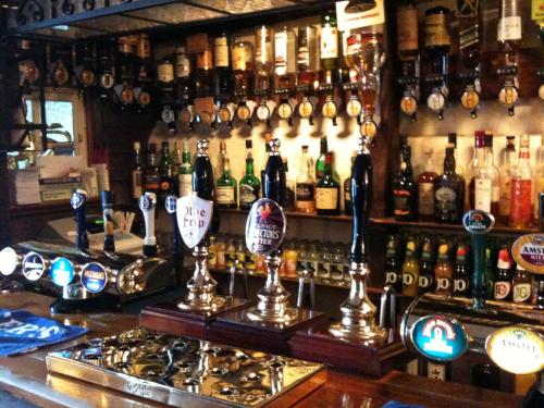 a bar with a lot of bottles of alcohol at The Crown Hotel in Mundford