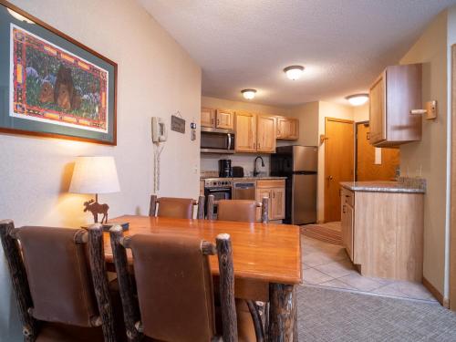 a kitchen with a wooden table and a dining room at Caribou Highlands Lodge in Lutsen
