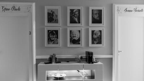 Zimmer mit Bildern an der Wand und einem Schreibtisch in der Unterkunft Granello Suite Central in Genua