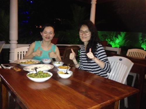 a man and a woman sitting at a table with food at Celestial Inn in Mirissa