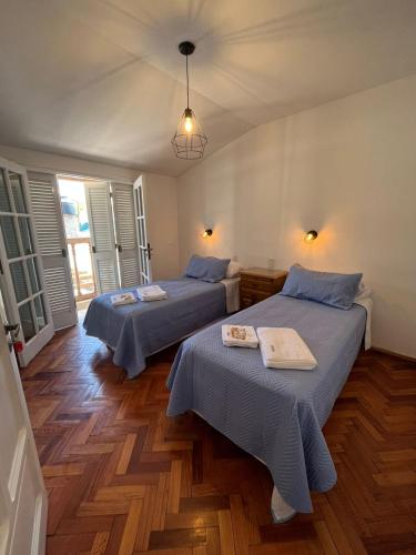 2 camas en una habitación con suelo de madera en Casa Chakana en San Rafael