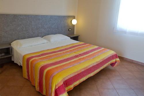 ラヴェンナにあるAutohotel Ravennaのベッドルーム1室(カラフルな毛布付きのベッド1台付)