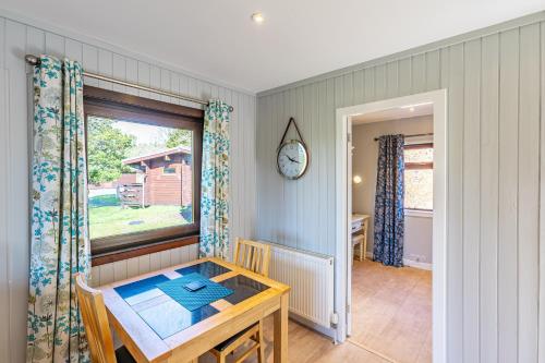a dining room with a table and a window at Bluebell Lodge 7 with Hot Tub in Newton Stewart