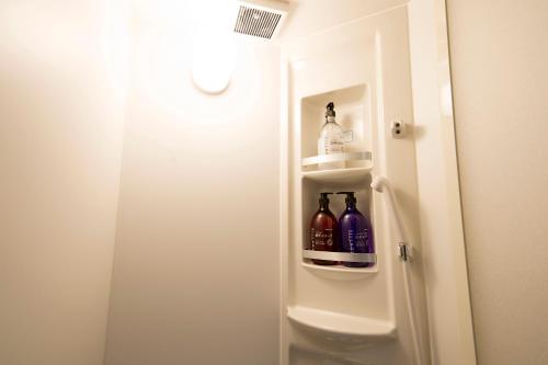 ein Badezimmer mit einem Kühlschrank mit Flaschen an der Tür in der Unterkunft akihabara marutomo hotel in Tokio